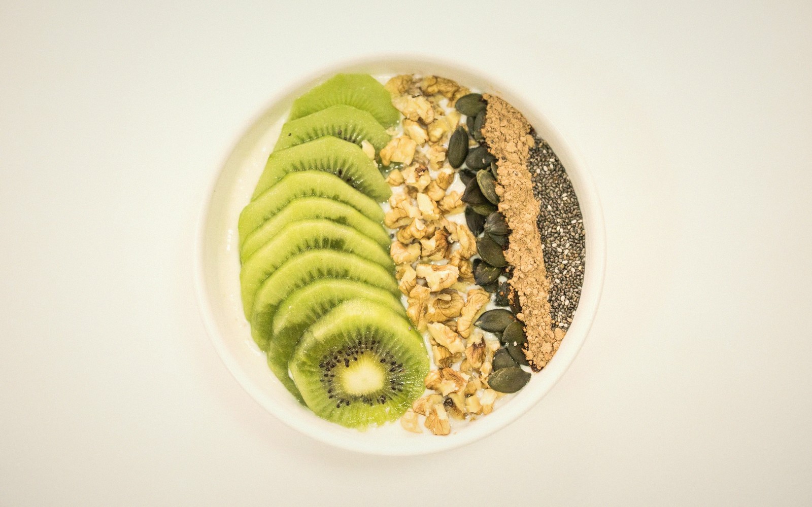 A thick smoothie bowl topped with fruit and granola